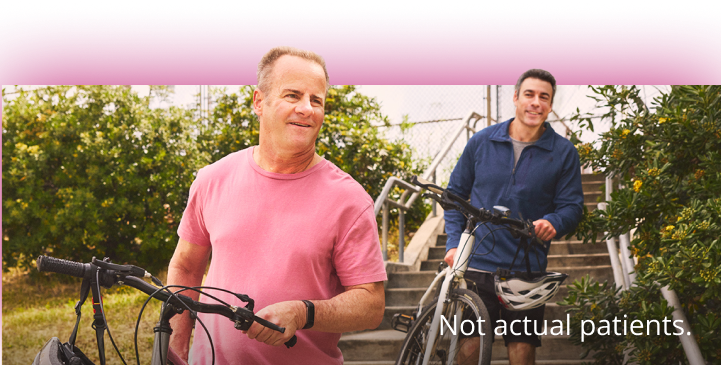 Two men holding bicycles. Not actual patients.