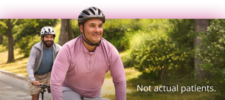 Two men riding bicycles wearing helmets. Not actual patients. 